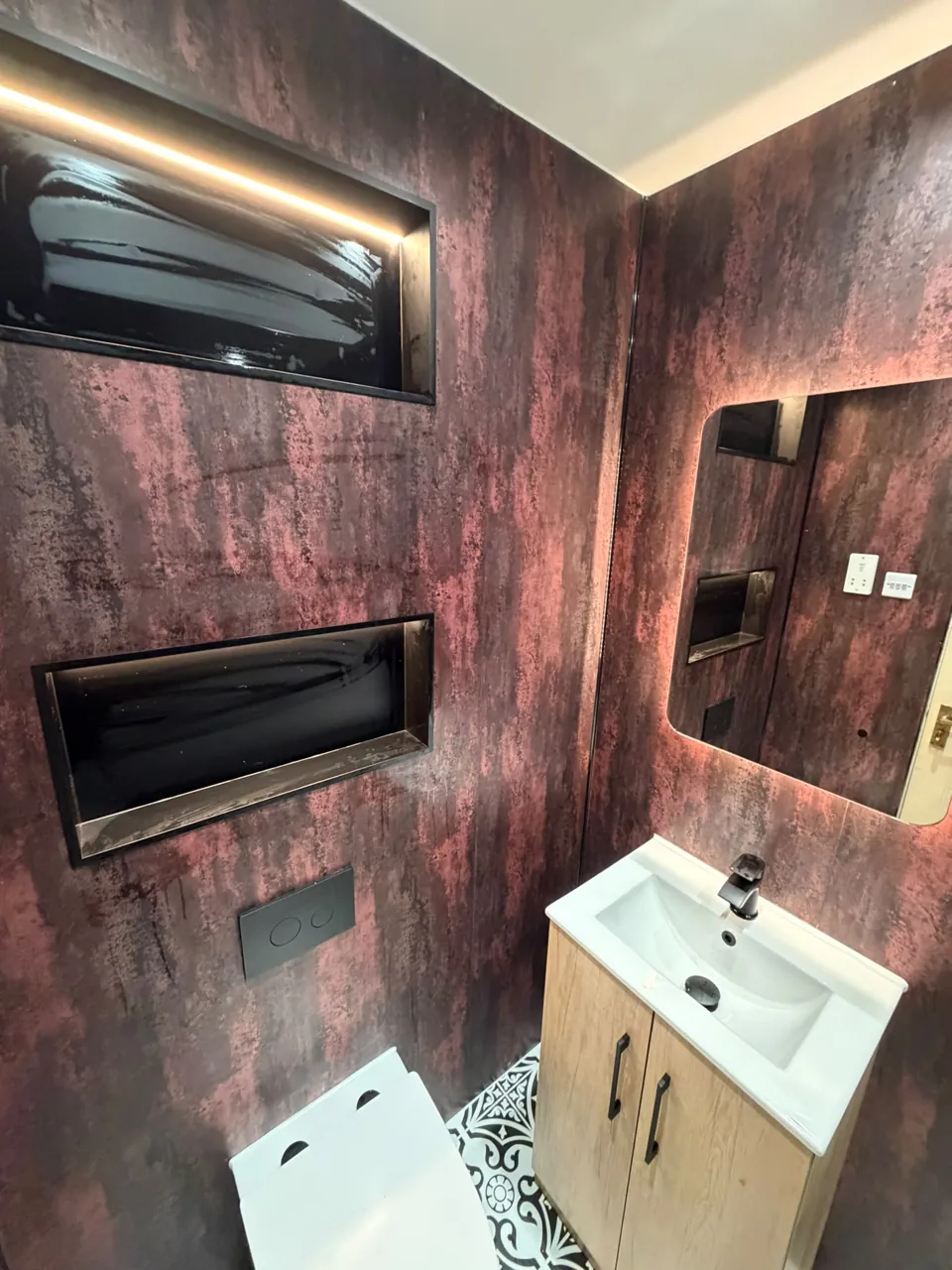 Compact basin and mirror against warm textured bathroom walls